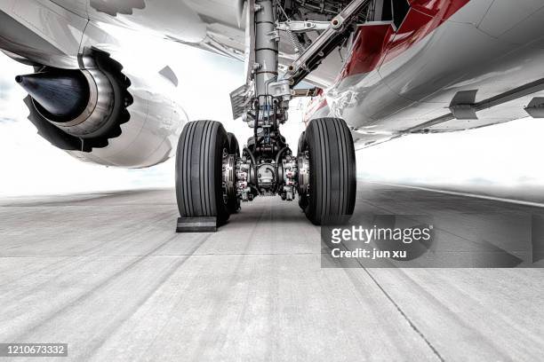 the huge wheels of the plane were parked on the runway of the airport - airplane runway stockfoto's en -beelden