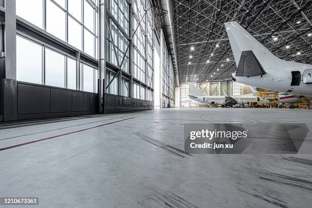 an empty, bright modern aircraft hangar - hangar stock-fotos und bilder