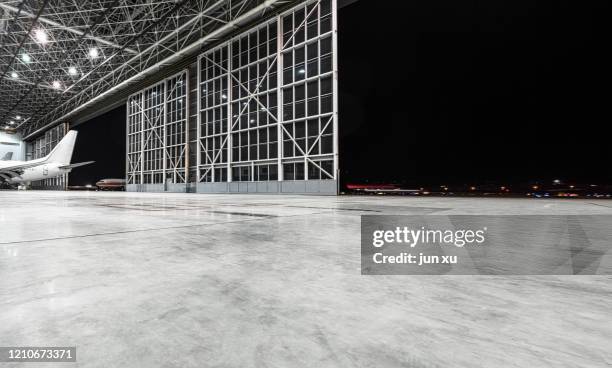 an empty, bright modern aircraft hangar - airplane hangar stock pictures, royalty-free photos & images