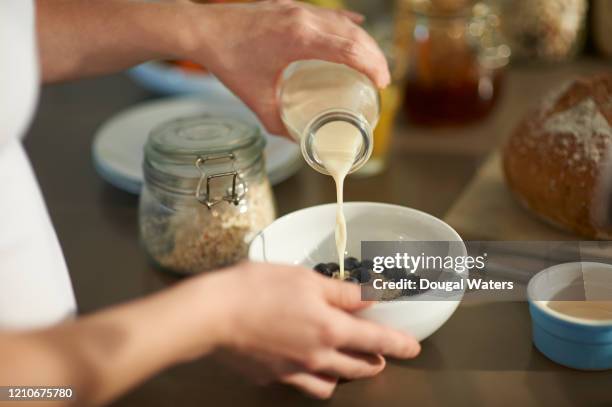 woman making healthy breakfast, close up. - milk pour - fotografias e filmes do acervo