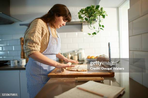 woman rolling out pastry in zero waste kitchen. - woman back stock-fotos und bilder