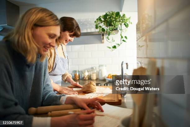 friends making pastry from recipe book in zero waste kitchen. - cooking with friends stock-fotos und bilder