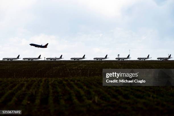 Southwest Airlines flight takes off as United Airlines planes sit parked on a runway at Denver International Airport as the coronavirus pandemic...