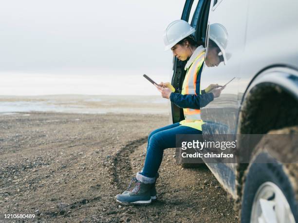 female oil worker using  tablet pc - mining natural resources stock pictures, royalty-free photos & images