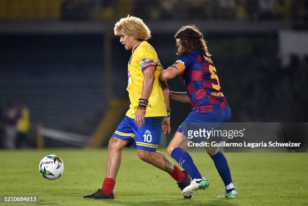 Carles Puyol of Barcelona legends vies for the ball with Carlos Valderrama of Colombia legends during an exhibition match between Colombia legends...
