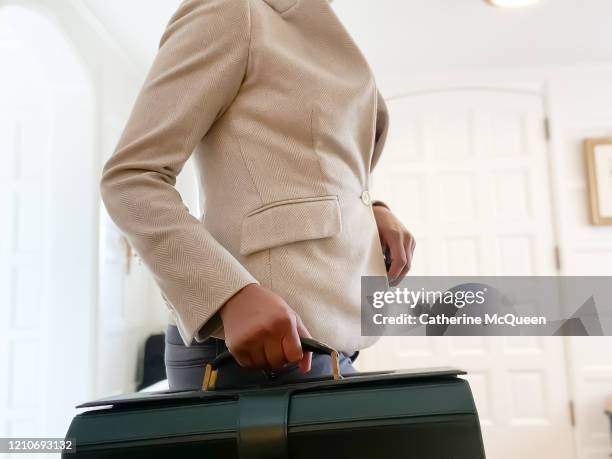 african-american woman prepares to leave home for work - equal pay day ストックフォトと画像