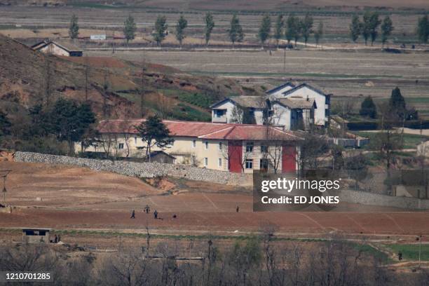 General view shows people, fields, and buildings of the North Korean countryside outside Kaesong, seen across the Demilitarized Zone from the South...