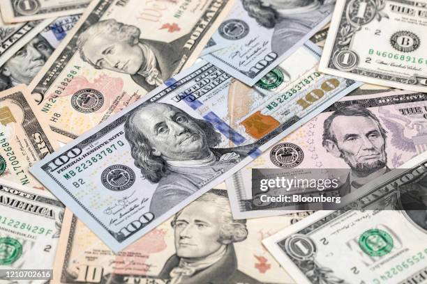 One-hundred dollar, ten-dollar, five-dollar and one-dollar banknotes are arranged for a photograph in Hong Kong, China, on Thursday, April 23, 2020....