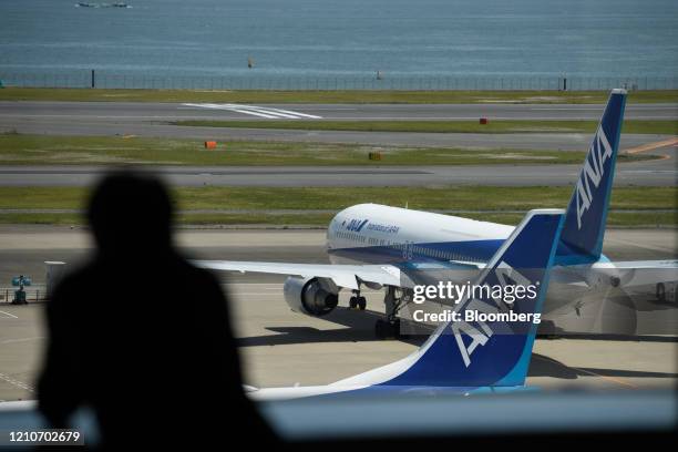Man looks at All Nippon Airways Co. Aircraft from a viewing area at Haneda Airport in Tokyo, Japan, on Thursday, April 23, 2020. Japans major...