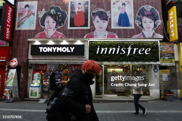 People wearing mask to prevent the coronavirus walks along the nearly empty Myeongdong shopping district on March 06, 2020 in Seoul, South Korea. The...