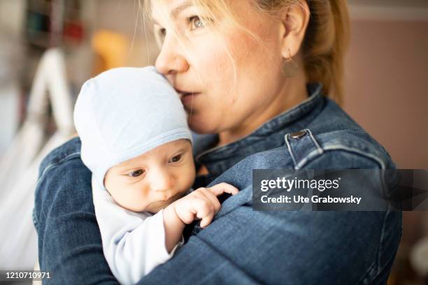 In this photo illustration a thoughtful mother holding her baby on April 21, 2020 in Bonn, Germany.