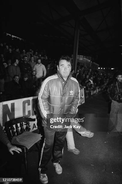 British football manager Brian Clough wearing a padded jacket, his hands in the pockets, as he stands in the dugout during the FA Cup Fourth Round...