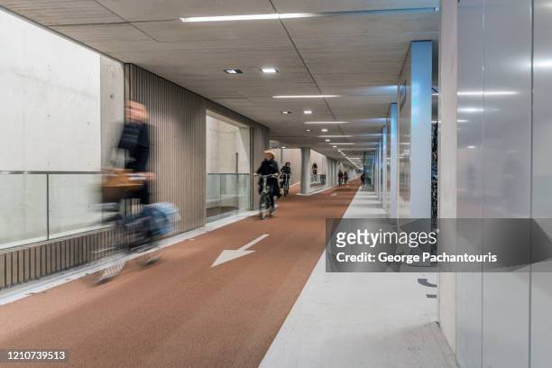 cyclists in the world's largest bicycle parking garage in utrecht, holland - utrecht stock pictures, royalty-free photos & images