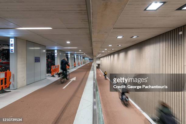 cyclists in the world's largest bicycle parking garage in utrecht, holland - utrecht city stock pictures, royalty-free photos & images