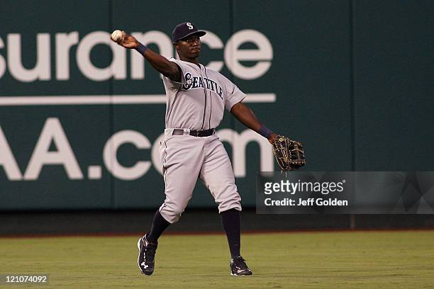 Trayvon Robinson of the Seattle Mariners throws the ball back to the infield after making his second catch to record an out in his Major League debut...