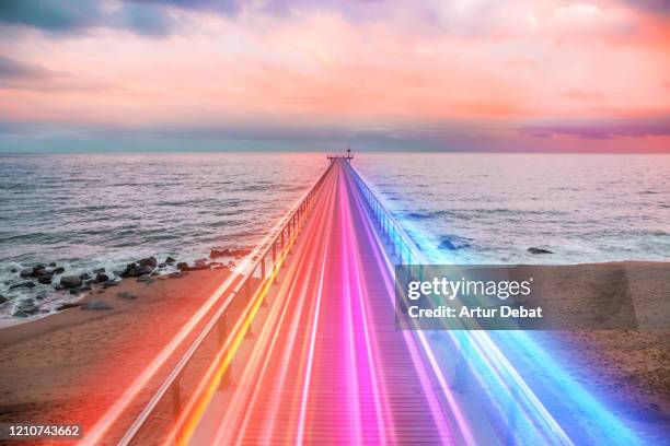 creative composition of colorful lights trails in motion over the sea. - beach night stockfoto's en -beelden