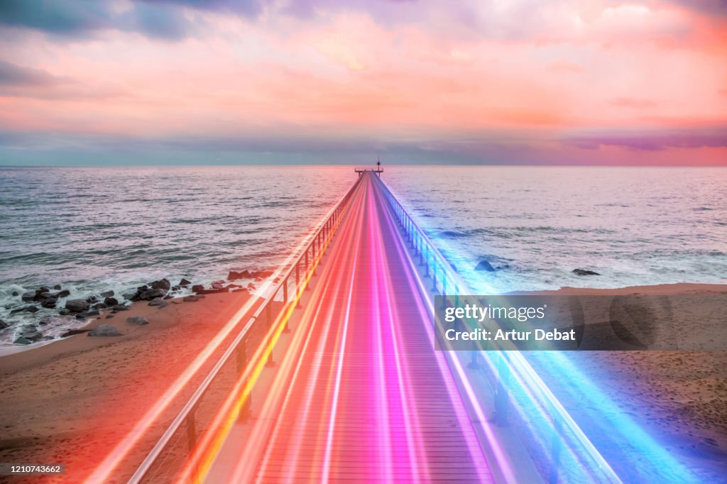 Creative composition of colorful lights trails in motion over the sea.