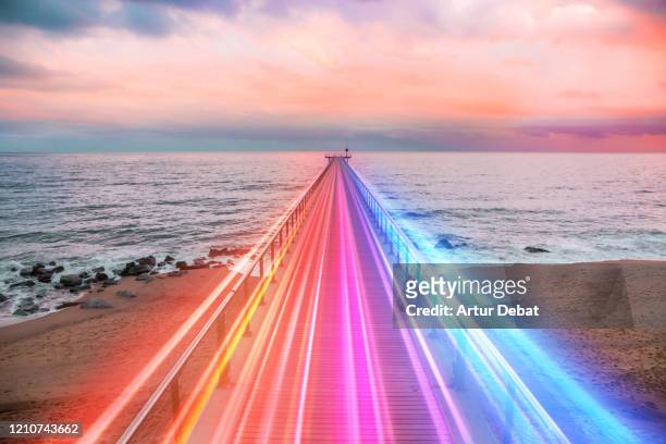 creative composition of colorful lights trails in motion over the sea. - romantic sky stock pictures, royalty-free photos & images