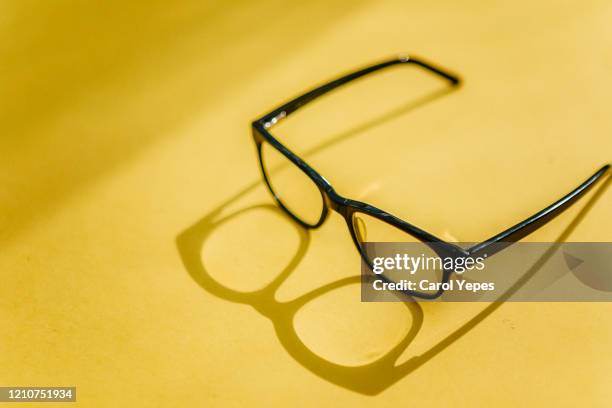 eyeglasses with shadow in yellow canvas - reading glasses imagens e fotografias de stock