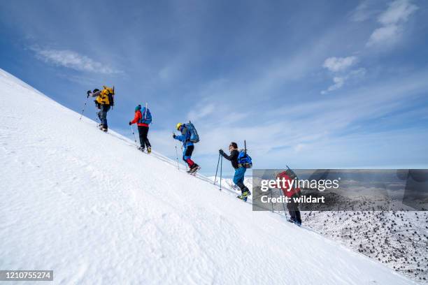 alpine bergbeklimmen team loopt naar de top van de grote hoogte berg in de winter - climbing a mountain stockfoto's en -beelden