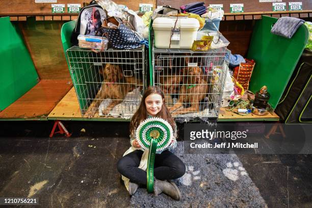 Young girl sits with a rosette on day 2 of the Cruft's dog show at the NEC Arena on March 6, 2020 in Birmingham, England. The annual four-day show...