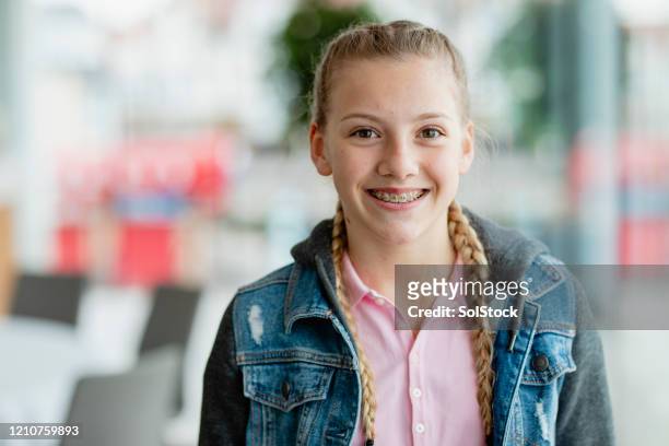 ragazza adolescente fiduciosa con le parentesi graffe, sorridente alla telecamera - youth portrait foto e immagini stock