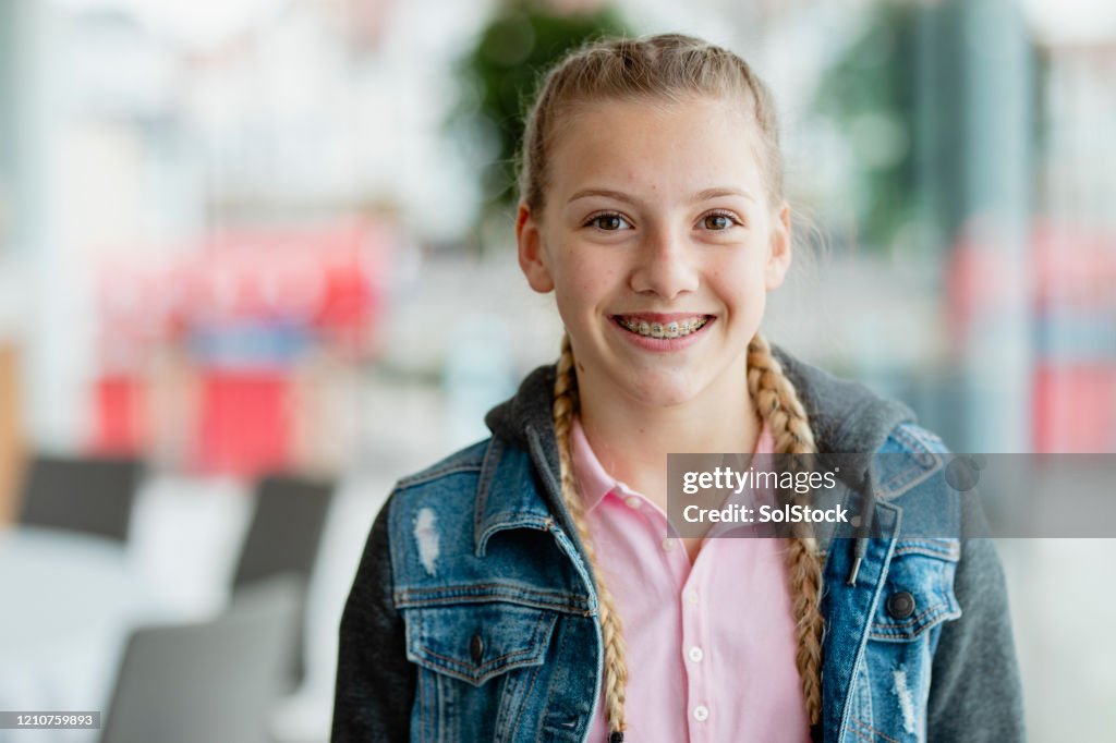 Confident teenage girl with braces, smiling at camera
