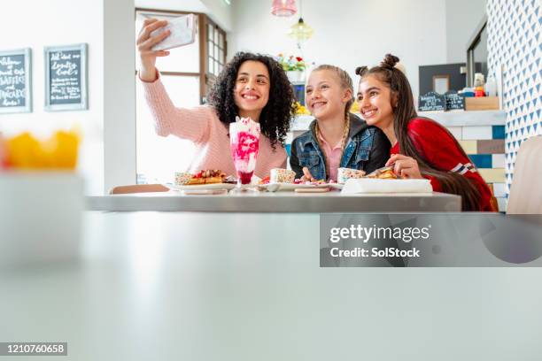 teenage mädchen machen selfie in diner - eisstockschießen stock-fotos und bilder