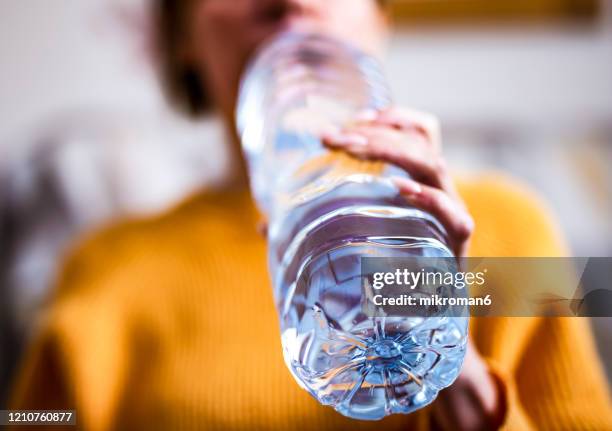 woman drinking mineral water from the bottle - lots of bottles stockfoto's en -beelden
