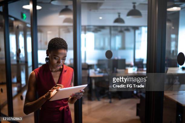 young businesswoman walking with digital tablet at coworking - application modernization stock pictures, royalty-free photos & images