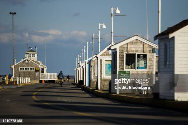Cyclist bikes down the McMillan Wharf marina on Cape Cod in Provincetown, Massachusetts, U.S., on Wednesday, April 22, 2020. Thousands of locals...