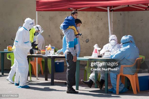 Man and his son waiting to be tested for antibodies or COVID-19 at the Roma neighborhood of Fakulteta in Sofia, Bulgaria on April 23, 2020. Fakulteta...