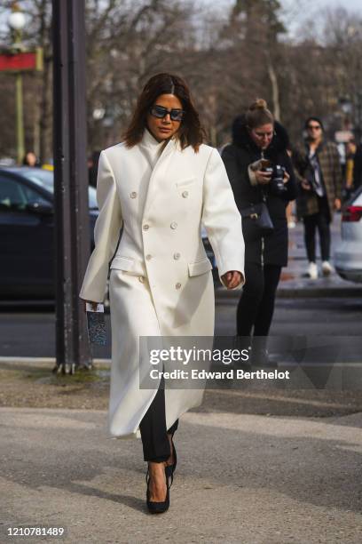 Christine Centenera wears sunglasses, a white long coat, pointy shoes, outside Chanel, during Paris Fashion Week - Womenswear Fall/Winter 2020/2021...