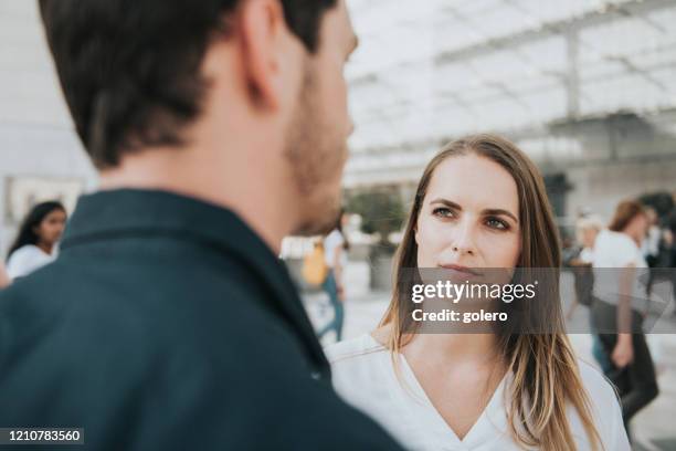 jeune femme écoutant de jeunes hommes à l’extérieur - individu étrange photos et images de collection