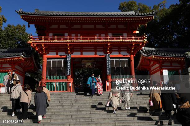 Foreign tourist couple dressed in Kimono as wearing face mask while walks through the shrine gate at Fushimi Inari-taisha shrine on March 06, 2020 in...