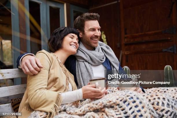 laughing couple drinking coffee on a bench outside on a cool morning - autumn coffee stock pictures, royalty-free photos & images