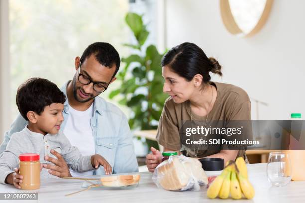 cheerful family making lunch together - peanut butter and jelly sandwich stock pictures, royalty-free photos & images