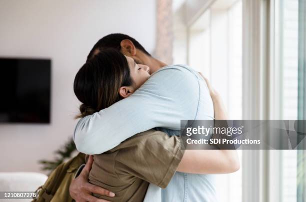 sad female soldier leaves home - embracing stock pictures, royalty-free photos & images