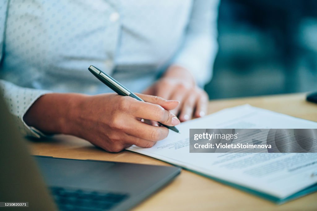 Businesswoman checking agreement before signing.