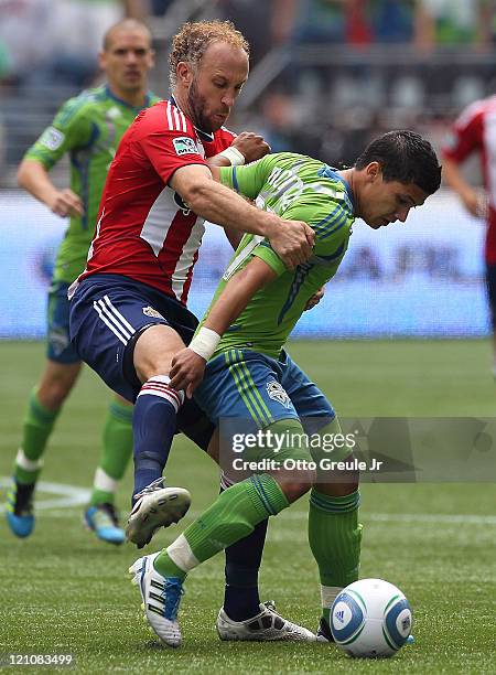 Fredy Montero of the Seattle Sounders FC battles Simon Elliott of Chivas USA at CenturyLink Field on August 13, 2011 in Seattle, Washington.