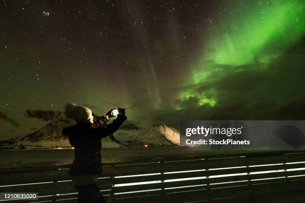 vrouw die een beeld van aurora neemt - ocean pictures stockfoto's en -beelden