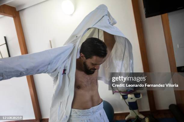 Venezuelan Karateka Antonio Jose Diaz Fernandez dons the buttonless jacket called his karategis uwagi before training and giving his karate class...