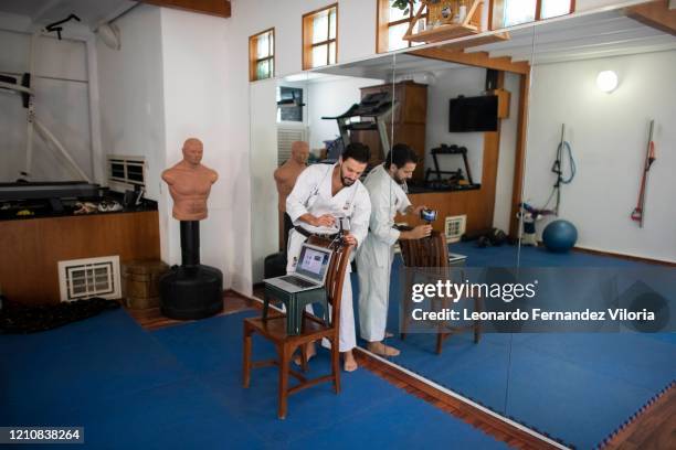 Venezuelan Karateka Antonio Jose Diaz Fernandez prepares a cell phone before starting his online karate lessons from his dojo during COVID-19...