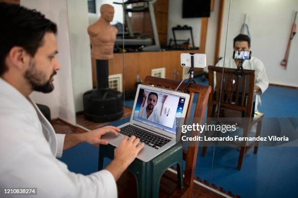 Venezuelan Karateka Antonio Jose Diaz Fernandez prepares the computer before starting his online karate lessons from his dojo during COVID-19...