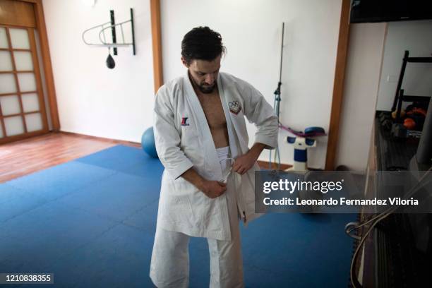 Venezuelan Karateka Antonio Jose Diaz Fernandez dons the buttonless jacket called his karategis uwagi before training and giving his karate class...