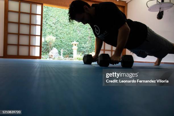 Venezuelan Karateka Antonio Jose Diaz Fernandez does some "man makers workout" during COVID-19 lockdown on April 22, 2020 in Caracas, Venezuela....