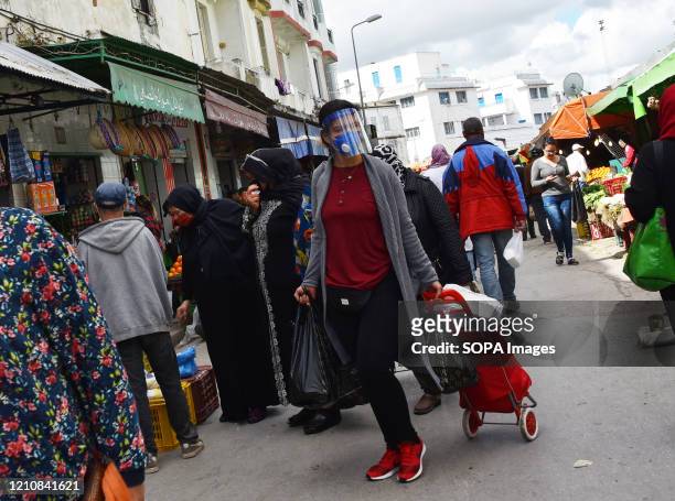 Tunisian woman wearing a plastic protective mask while doing preparation shopping a day before Ramadan. Muslims around the world will begin the holy...
