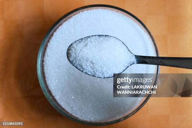 This photo illustration taken on April 22, 2020 shows a teaspoon of sugar, an item that has been in short supply in Sri Lanka as a result of the...