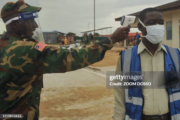 Doctor Jerry Brown gets his temparature measured at the 14 Military Hospital in Monrovia on April 15, 2020. - Many Liberians remember Jerry Brown,...