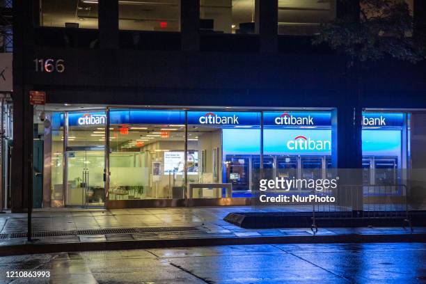 Citibank bank branch at 6th Avenue in New York City, USA as seen during the night with ATM and illuminated logo. Citibank financial institution is...